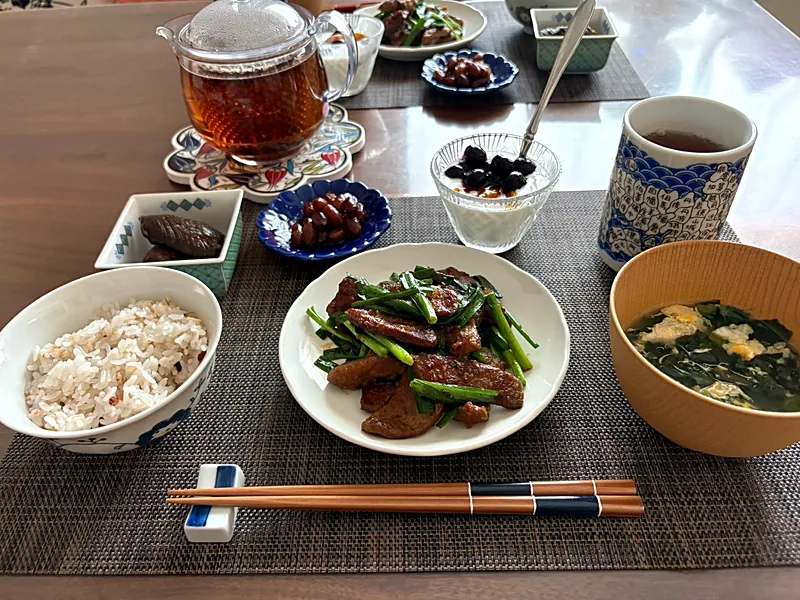 Japanese breakfast with stir-fried liver and garlic chives, a bowl of multigrain rice, egg and wakame soup, small side dishes and tea